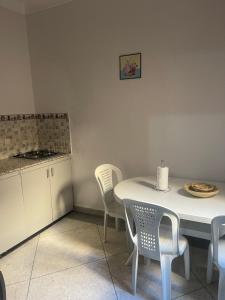 uma cozinha com uma mesa e cadeiras brancas e um balcão em Appartement near to AirPort 262 avenue el khalij em Marrakech