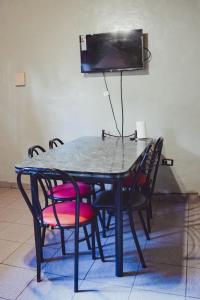 einen schwarzen Tisch mit Stühlen und einen TV an der Wand in der Unterkunft DEPARTAMENTOS DE ELVIRA ARAVENA in Malargüe
