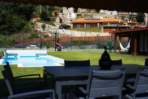 una mesa y sillas frente a una piscina en Villa Ramiro en Celorico de Basto