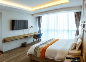 ein Hotelzimmer mit einem Bett, einem Schreibtisch und einem TV in der Unterkunft Gold Source Hotel in Lima