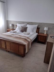 1 dormitorio con 1 cama grande y 2 mesitas de noche en Tandem apartman, en Kápolnásnyék