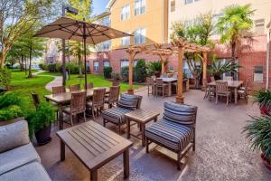 un patio con mesas, sillas y una sombrilla en Homewood Suites by Hilton Baton Rouge en Baton Rouge