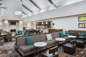 a living room with a couch and tables and chairs at Homewood Suites by Hilton Baton Rouge in Baton Rouge