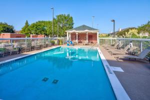 a swimming pool with chairs and a gazebo at Homewood Suites by Hilton Baton Rouge in Baton Rouge