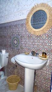 baño con lavabo y espejo en la pared en Riad Hayat, en Marrakech
