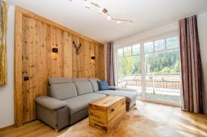 ein Wohnzimmer mit einem Sofa und einem großen Fenster in der Unterkunft Apartments Summer & Winter Fun by All in One Apartments in Zell am See