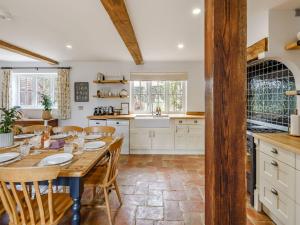 cocina con mesa de madera y sillas en Chittering Farm, en Stretham