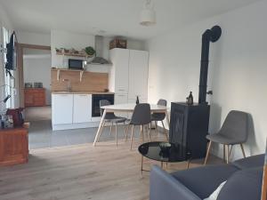 een keuken en een woonkamer met een tafel en stoelen bij Maisonnette in Corbeil-Essonnes