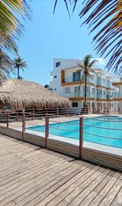 uma piscina ao lado de um edifício com palmeiras em Apartamento 201 Palmar de los vientos em San Bernardo del Viento