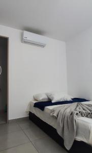 ein Schlafzimmer mit einem Bett mit einer weißen Wand in der Unterkunft Apartamento 201 Palmar de los vientos in San Bernardo del Viento