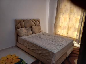 ein Schlafzimmer mit einem Bett in einem Zimmer mit einem Fenster in der Unterkunft Dari A10 in Agadir