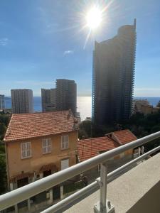 einen Balkon mit Blick auf die Stadt und die Sonne in der Unterkunft Lovely flat border to Monaco- private parking - sea view and terrace in Beausoleil