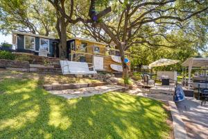 a house with a bench and a tree at Waterfront Lake LBJ Cabin with Private Dock! in Burnet
