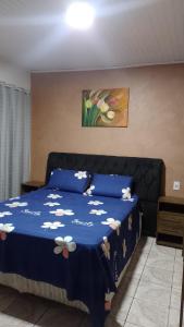 a bedroom with a blue bed with flowers on it at Casa Gil in Foz do Iguaçu