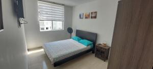 a small bedroom with a bed and a window at Aqualina Orange Apartamento Piso 6 Vista a Piscina 3 Habitaciones in Girardot