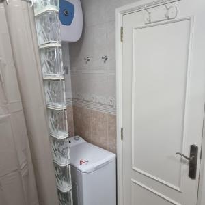 a bathroom with a white toilet and a white door at Serenity Garden in Maspalomas