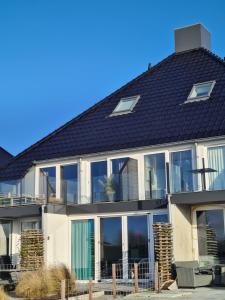 a house with large windows and a roof at Welkom in mijn Studio bij het Snekermeer ! in Offingawier