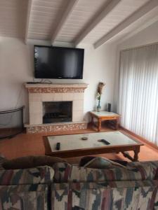 a living room with a couch and a fireplace at Rosarito #12 beach front in Rosarito