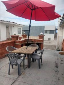a picnic table with a red umbrella on a patio at Rosarito #12 beach front in Rosarito