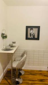 een tafel en stoel in een kamer met een foto aan de muur bij The elegant Garden Room in Blackpool