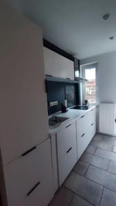 a kitchen with white cabinets and a sink at Ein Haus für sich in Lübeck