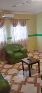 a living room with a green couch and a coffee table at Executive Lodge in Kasoa