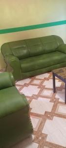 a green couch in a living room with a table at Executive Lodge in Kasoa
