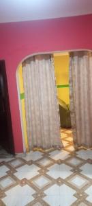 a room with two windows with curtains on a wall at Executive Lodge in Kasoa