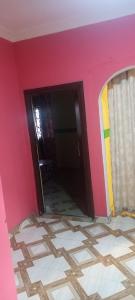 a room with a pink wall and a doorway at Executive Lodge in Kasoa