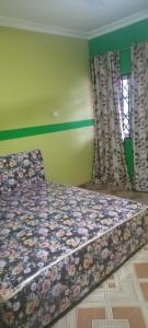 a bedroom with a bed with a floral bedspread at Executive Lodge in Kasoa