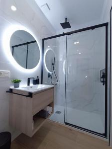 bagno con doccia, lavandino e specchio di RAMBLA DREAMS Nuevo apartamento céntrico y 1GB a Santa Cruz de Tenerife