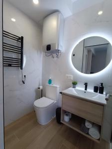 ein Badezimmer mit Toilette, Waschbecken und Spiegel in der Unterkunft RAMBLA DREAMS Nuevo apartamento céntrico y 1GB in Santa Cruz de Tenerife