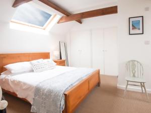 a bedroom with a bed and a chair in it at Half Penny Cottage in Docking