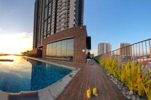 a woman standing next to a swimming pool next to a building at LoveStayBangi - Muji in Bandar Baru Bangi +58 photos