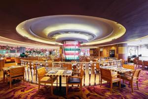Renaissance Shanghai Pudong Hotel في شانغهاي: غرفة طعام على سفينة سياحية مع طاولات وكراسي