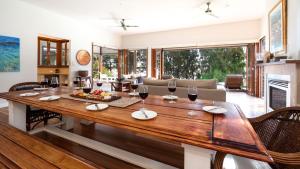 a living room with a wooden table with wine glasses at Tula in Currarong