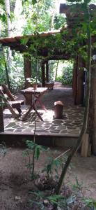 un patio con mesa de picnic y banco en Chalé O Canto dos Pássaro en Parati