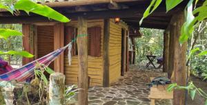 uma rede em frente a um chalé de madeira em Chalé O Canto dos Pássaro em Paraty