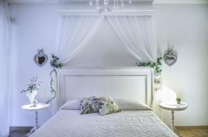 a bedroom with a white bed with two tables at B&B Il Cuore in Massa