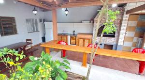 um pátio com uma mesa de madeira e uma cozinha em Casa com piscina - Praia do Pernambuco no Guarujá