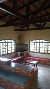 um quarto com mesas e janelas vermelhas e rosas em Recanto dos Passáros Penedo RJ em Penedo