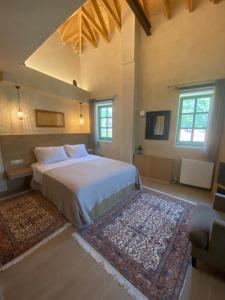 - une chambre avec un grand lit et un tapis dans l'établissement Aristi boutique stonehouse with attic, à Aristi