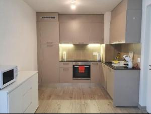 a large kitchen with white cabinets and a microwave at Jacqueline residence in Sion