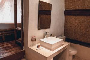 bagno con lavandino bianco e servizi igienici di Ekas Breaks Resort a Ekas