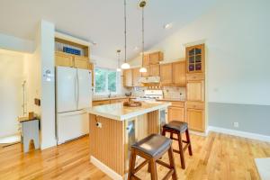 a kitchen with wooden cabinets and a white refrigerator at Spacious Lakefront New Auburn Home with Sunroom in Chetek