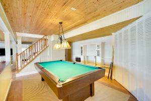 a pool table in a room with a ceiling at Spacious Lakefront New Auburn Home with Sunroom in Chetek