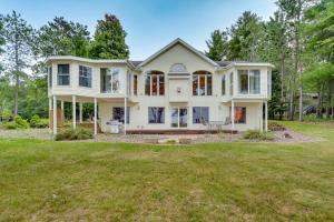 a large white house with a yard at Spacious Lakefront New Auburn Home with Sunroom in Chetek