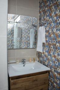 ein Bad mit einem Waschbecken und einem Spiegel in der Unterkunft NORTE REAL HOTEL in Cali