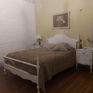 a bedroom with a bed with two night stands and two tables at La Glicina casa in La Plata