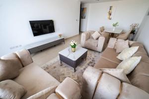 a large living room with couches and a tv at Elegant 2BR near Palm Jumeirah - 6 Min Drive in Dubai
